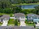Angled aerial view of the home with lake view, highlighting its proximity to water and quiet neighborhood setting at 13735 Wineberry Dr, Dade City, FL 33525