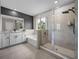 Modern primary bathroom with granite vanity, soaking tub and glass enclosed shower at 13735 Wineberry Dr, Dade City, FL 33525