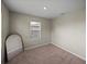 Cozy bedroom featuring neutral paint, carpet, and a bright window at 13735 Wineberry Dr, Dade City, FL 33525