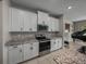 Bright kitchen features white cabinets, granite countertops, and stainless steel appliances at 13735 Wineberry Dr, Dade City, FL 33525