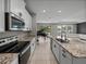 Kitchen view showcasing granite countertops, stainless steel appliances, and open floorplan to living area at 13735 Wineberry Dr, Dade City, FL 33525