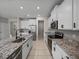 Modern kitchen features white cabinets, granite countertops, stainless steel appliances and a spacious island with a sink at 13735 Wineberry Dr, Dade City, FL 33525