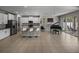 Open-concept living room with a modern kitchen island, white cabinets and barstools, and a classic piano at 13735 Wineberry Dr, Dade City, FL 33525