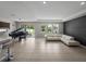 Spacious living room featuring a piano, tile flooring, neutral walls, and sliding glass doors leading to the backyard at 13735 Wineberry Dr, Dade City, FL 33525