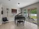 Living room with piano and sliding glass doors leading to backyard at 13735 Wineberry Dr, Dade City, FL 33525