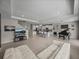 Open-concept living space with a modern kitchen, large island, cozy white sofa, and sleek entertainment setup at 13735 Wineberry Dr, Dade City, FL 33525