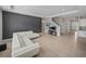 Spacious living area with tile floors, white sofa, TV, and a gray accent wall; bright and airy design at 13735 Wineberry Dr, Dade City, FL 33525