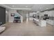 Open concept living area with modern kitchen island, stainless steel appliances, and a large TV at 13735 Wineberry Dr, Dade City, FL 33525