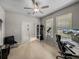 Bright home office with a ceiling fan, computer, and charming double-door entrance at 13735 Wineberry Dr, Dade City, FL 33525