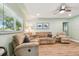 Cozy living room featuring a plush sectional sofa, ceiling fan, and light wood-look flooring at 1529 Essex N Dr, St Petersburg, FL 33710