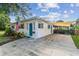 Single-story home featuring a covered parking area and a well-maintained white exterior with blue accents at 1529 Essex N Dr, St Petersburg, FL 33710