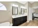 Well-lit bathroom features a double sink vanity with dark wood cabinets, a large mirror and framed vanity mirror at 1649 Ledgestone Dr, Brandon, FL 33511