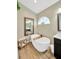 Elegant bathroom features a freestanding tub with modern fixtures, wood-look tile floor, and a double sink vanity at 1649 Ledgestone Dr, Brandon, FL 33511