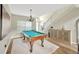 Spacious game room with a billiard table, modern chandelier, and wooden floors at 1649 Ledgestone Dr, Brandon, FL 33511