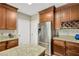 Open kitchen with stainless steel refrigerator, wooden cabinets, and wine rack at 1649 Ledgestone Dr, Brandon, FL 33511