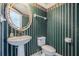 Cozy powder room with patterned wallpaper and a pedestal sink at 16600 Gulf Blvd # 437, North Redington Beach, FL 33708