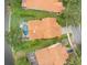 Aerial view of a beautiful home featuring a screened-in pool, lush landscaping, and waterfront at 18917 Avenue Biarritz, Lutz, FL 33558