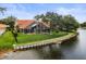 Stunning backyard view featuring a screened-in pool, waterfront access, and meticulously manicured lawn at 18917 Avenue Biarritz, Lutz, FL 33558
