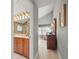 Hallway view into the primary bathroom, with double sink vanity and glass enclosed shower at 18917 Avenue Biarritz, Lutz, FL 33558