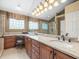 Bathroom featuring a dual sink vanity with granite countertops and a glass enclosed shower at 18917 Avenue Biarritz, Lutz, FL 33558