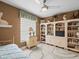 Bedroom with hardwood floors, ceiling fan, and built-in shelving at 18917 Avenue Biarritz, Lutz, FL 33558