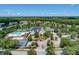 Aerial view of the community clubhouse, pool, tennis courts and lush green landscaping at 18917 Avenue Biarritz, Lutz, FL 33558