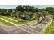 Beautiful community entrance with lush landscaping, mature palm trees, and pond with fountain at 18917 Avenue Biarritz, Lutz, FL 33558