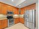 Modern kitchen equipped with stainless steel appliances, wooden cabinets, and granite countertops at 18917 Avenue Biarritz, Lutz, FL 33558