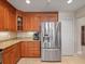 Updated kitchen showcasing stainless steel refrigerator, granite countertops, and stylish wooden cabinetry at 18917 Avenue Biarritz, Lutz, FL 33558