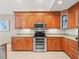 This is a contemporary kitchen with granite countertops, wooden cabinetry, and modern stainless steel appliances at 18917 Avenue Biarritz, Lutz, FL 33558