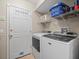 Well-equipped laundry room with modern washer and dryer, shelving, and easy access to the outdoors at 18917 Avenue Biarritz, Lutz, FL 33558