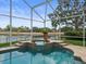 Enclosed pool with lush landscaping and waterfront view at 18917 Avenue Biarritz, Lutz, FL 33558