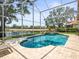 Beautiful screened-in pool area with comfortable lounge chairs, lake views, and serene outdoor living at 18917 Avenue Biarritz, Lutz, FL 33558