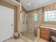 Well-lit glass enclosed shower with neutral tile work, and granite vanity at 18917 Avenue Biarritz, Lutz, FL 33558