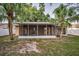 Backyard featuring a screened-in patio, privacy fence, and mature trees, perfect for relaxation at 2010 Groveland Rd, Palm Harbor, FL 34683