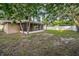 Large backyard with mature landscaping, a screened-in patio, and privacy fencing for outdoor enjoyment at 2010 Groveland Rd, Palm Harbor, FL 34683