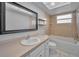 Bright bathroom featuring a vanity, mirror, tub and shower at 2010 Groveland Rd, Palm Harbor, FL 34683