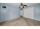 This bedroom features a ceiling fan, closet and neutral walls and carpeting at 2010 Groveland Rd, Palm Harbor, FL 34683