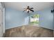 This bedroom features a ceiling fan, sliding glass door and neutral walls and carpeting at 2010 Groveland Rd, Palm Harbor, FL 34683