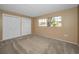 This bedroom features two large closets, a window and neutral walls and carpeting at 2010 Groveland Rd, Palm Harbor, FL 34683