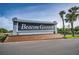 A welcoming entrance sign for Beacon Groves featuring lush landscaping and a brick base with a clear blue sky backdrop at 2010 Groveland Rd, Palm Harbor, FL 34683