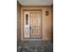 Exterior view of the front door and covered entry showing the adjacent sidelight and exterior lantern at 2010 Groveland Rd, Palm Harbor, FL 34683