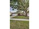 Inviting single-story home with a large tree, a well-kept lawn, and an attached garage at 2010 Groveland Rd, Palm Harbor, FL 34683