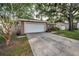 Single-story home with attached garage, well-maintained lawn, and a tree in the front yard at 2010 Groveland Rd, Palm Harbor, FL 34683