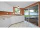 Bright kitchen features white cabinets, stainless steel sink and sliding glass doors to the backyard patio at 2010 Groveland Rd, Palm Harbor, FL 34683