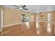 Bright living room with wood flooring, ceiling fans, and sliding glass doors to the porch at 2010 Groveland Rd, Palm Harbor, FL 34683