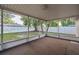 Spacious screened patio providing a tranquil view of the fenced backyard and greenery at 2010 Groveland Rd, Palm Harbor, FL 34683