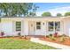 Charming single-story home with a bright white exterior, decorative shutters, and beautifully landscaped front yard at 2017 Rebecca Dr, Clearwater, FL 33764