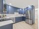 Modern kitchen with stainless steel appliances, navy cabinetry and white backsplash at 2017 Rebecca Dr, Clearwater, FL 33764