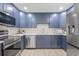 Renovated kitchen features navy cabinets, stainless appliances, stylish backsplash, and countertop space at 2017 Rebecca Dr, Clearwater, FL 33764